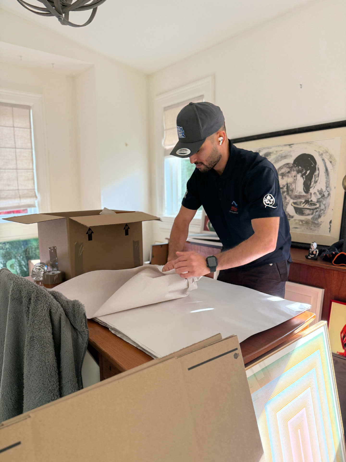 Professional packers wrapping glassware and artwork in a Whistler home